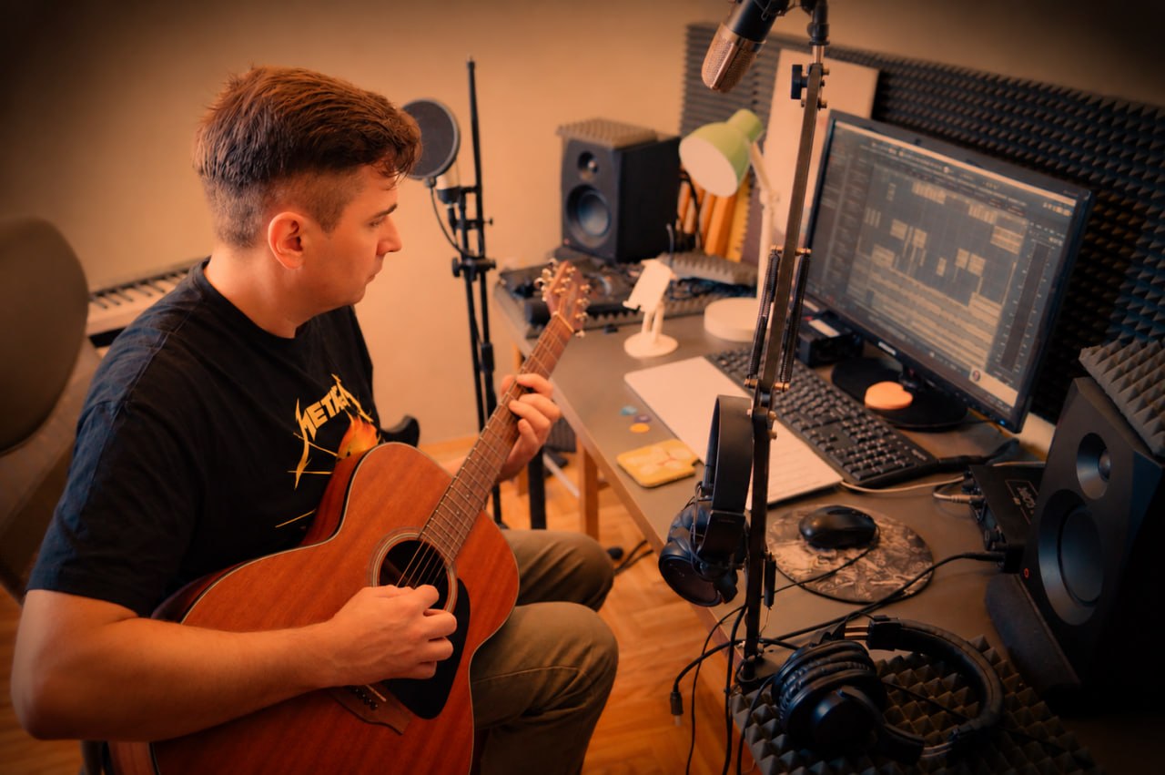 Alexander AVAMIR Abramov composing with a guitar in his studio